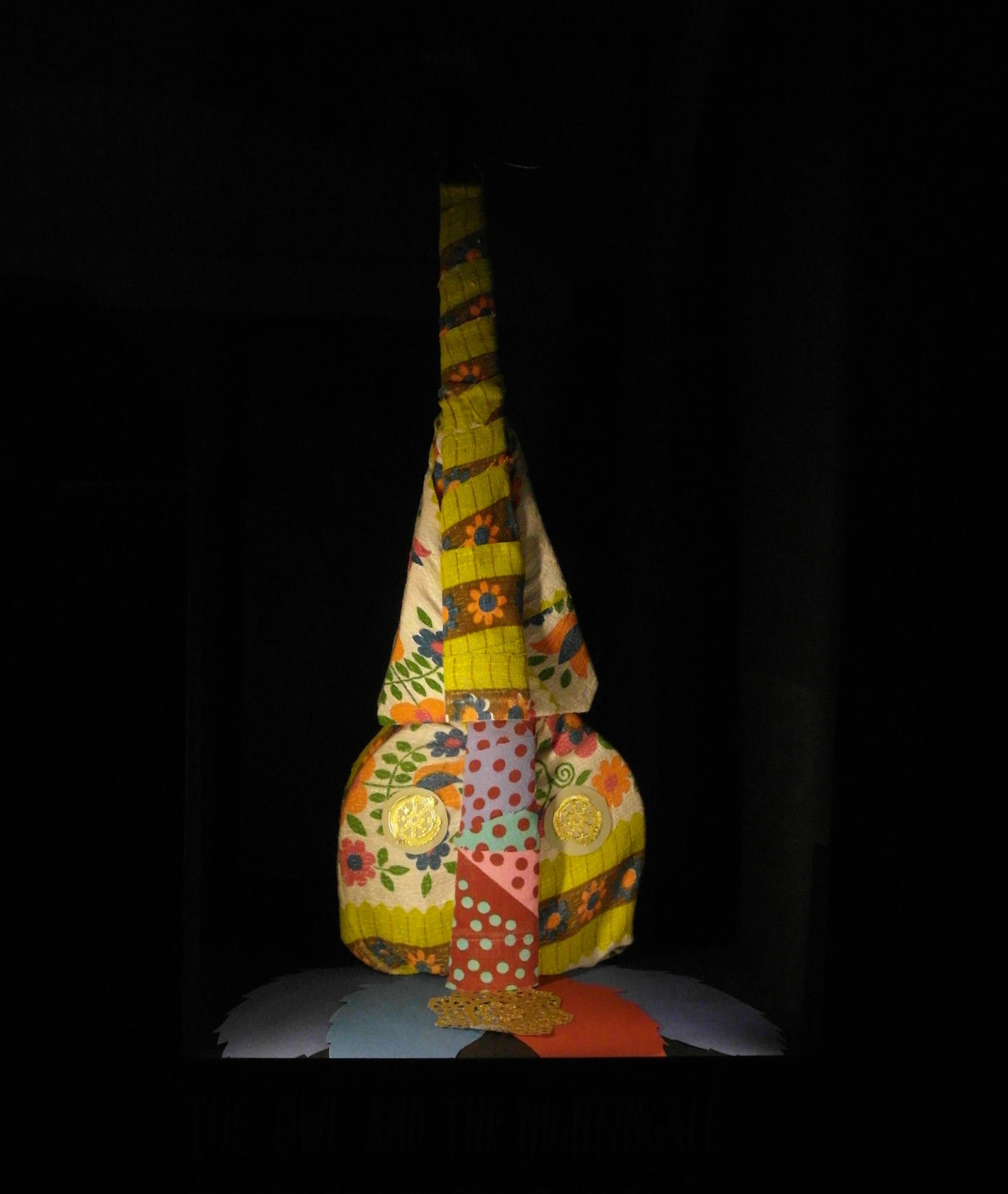 Sculpture made of violin part wrapped with fabric and additional cutted out paper.