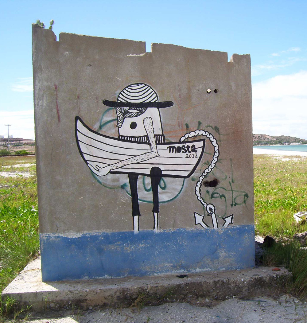 Painted character on wall of small abandoned house at the beach.